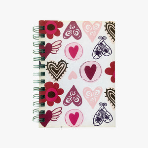 5x7  Spiral Hearts Journal. Top view of cover shown. Varied, stylized, drawings of hearts and flowers in pinks on an off white background. Shop a selection of notebooks & journals at blueigloo.ca 