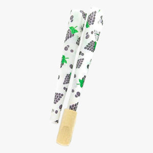 Juicy Jay's Pre-rolled Cones-2 pk, Grape. Shown two pre-rolled cones with cartoon grapes printed randomly on the white paper with the Dank 7 tip inserted onto one of the pre-rolled cone ends. Shop rolling papers, pre-rolled cones and smoking accessories at blueigloo.ca