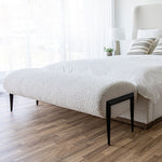 Load image into Gallery viewer, Fisher Bench shown at the end of a bed upholstered in the same fabric as the bench with a white duvet and striped off-white throw cushions. Shop benches and stools online at blueigloo.ca.
