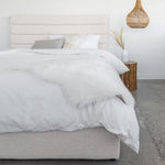 Load image into Gallery viewer, Justin Storage Bed-Tall, Cream by Style In Form. Lifestyle shot of bed in white room with concrete floor, bed dressed with duvet, pillows and fur throw. View from end of bed. Shop vintage &amp; new home décor, lighting &amp; home furnishings as well as novelty gifts &amp; pet accessories online at blueigloo.ca
