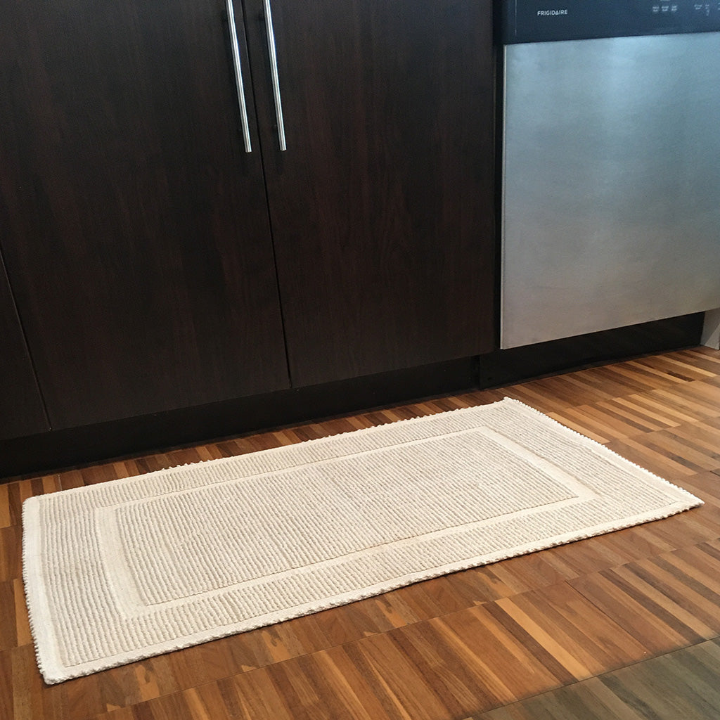 Payal Floor Mat. Color: Beige. Lifestyle shot showing mat on the floor in front of a kitchen cupboard with a dishwasher to the right. Shop vintage & new home décor, lighting & home furnishings as well as novelty gifts & pet accessories online at blueigloo.ca