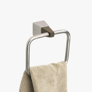 Quatra Towel Ring. A square, brushed nickel towel ring, the ring is held by a dark wood connecter between the wall mount that is also in brushed aluminum   Shown mounted to a wall with a beige hand towel (not included) hanging from it. Shop a selection of Umbra  bathroom hardware, towel hooks and other bathroom accessories at blueigloo.ca 