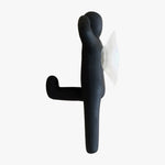 Load image into Gallery viewer, Resin Figure Hook, Black. Side view. A suction hook shaped like a person, right arm raised touching side of head, left arm straight by side. Left leg lifted at waist height, right leg straight down. Shop suction hooks and other bath accessories at blueigloo.ca
