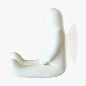 Resin Figure Hook, White. Side view. A suction hook shaped like a person sitting with their arms resting on the top of their thighs. Legs are extended straight out in front of them. Shop suction hooks and other bath accessories at blueigloo.ca
