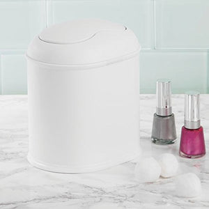 Vanity Waste Can by Inter Design. Lifestyle shot showing the can on a marble countertop with 2 bottles of nail polish and 3 cotton balls to the left of the can on an off white background. Front angled view. Shop vintage & new home décor, lighting & home furnishings as well as novelty gifts & pet accessories online at blueigloo.ca